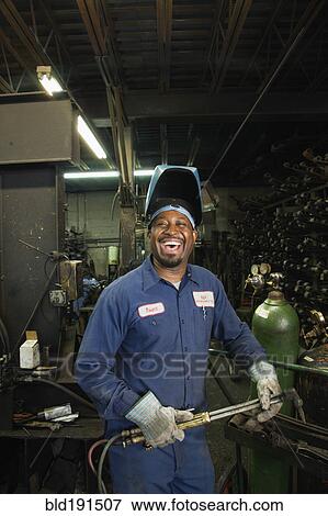 Stock Photo - African welder working in repair shop. Fotosearch