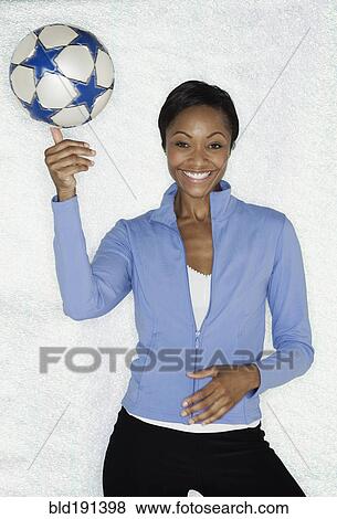 Stock Photo - African woman balancing soccer ball. Fotosearch