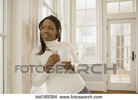 Picture - African woman holding coffee cup. Fotosearch