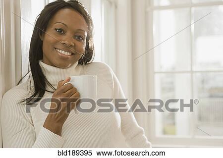 Stock Photography - African woman holding coffee cup. Fotosearch