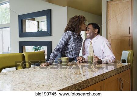 African woman kissing husband in modern kitchen View Large Photo Image Stock Photography - African woman kissing husband in modern kitchen. Fotosearch