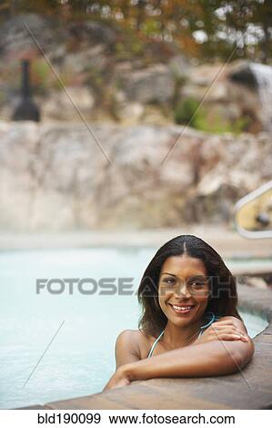 Stock Photo - African woman sitting in hot tub. Fotosearch