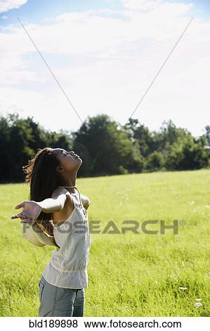 African woman standing in meadow with arms outstretched View Large Photo Image Stock Photo - African woman standing in meadow with arms outstretched. Fotosearch