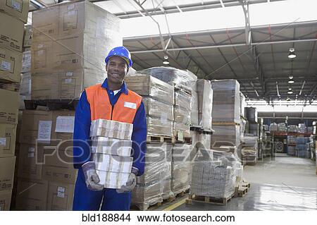 African worker carrying package in warehouse View Large Photo Image Picture - African worker carrying package in warehouse. Fotosearch