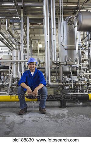 Stock Image - African worker sitting in factory. Fotosearch