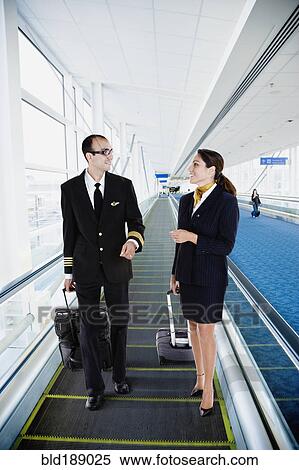 Stock Photography - Airline employees on moving walkway in airport. Fotosearch