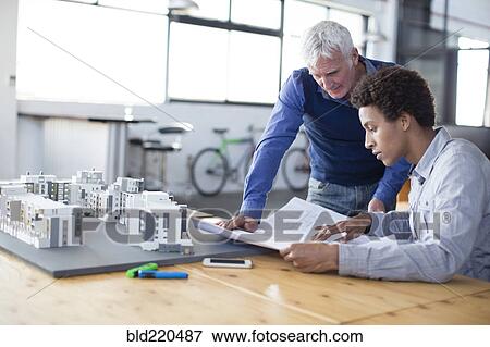 Architects examining architectural model in office View Large Photo Image Stock Photo - Architects examining architectural model in office. Fotosearch
