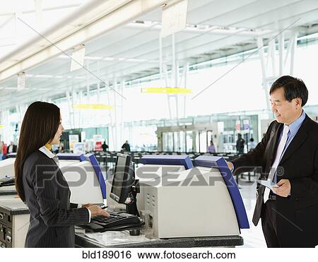 Stock Photograph - Asian businessman checking in at airport. Fotosearch