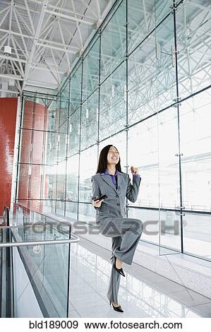 Asian businesswoman celebrating in airport View Large Photo Image Stock Photo - Asian businesswoman celebrating in airport. Fotosearch