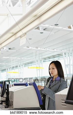 Stock Photography - Asian businesswoman checking in at airport. Fotosearch