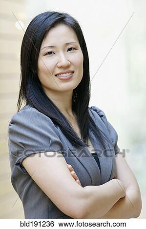 Stock Photograph - Asian businesswoman smiling in office. Fotosearch