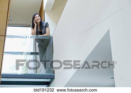 Asian businesswoman talking on cell phone in office View Large Photo Image Stock Image - Asian businesswoman talking on cell phone in office. Fotosearch