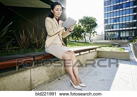 Asian businesswoman using digital tablet outdoors View Large Photo Image Stock Image - Asian businesswoman using digital tablet outdoors. Fotosearch