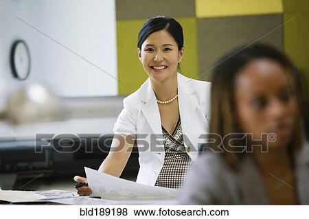 Stock Photo - Asian businesswoman working at desk. Fotosearch