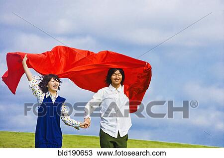 Asian couple holding blanket in wind View Large Photo Image Stock Image - Asian couple holding blanket in wind. Fotosearch