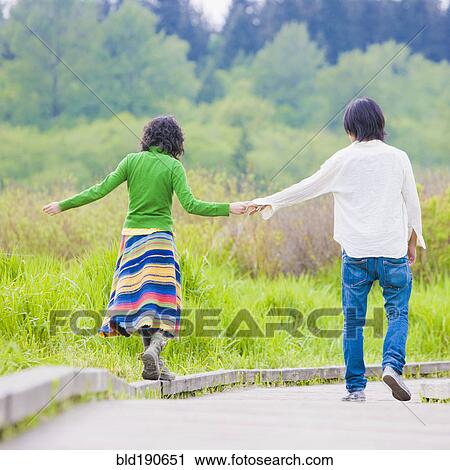Stock Image - Asian couple holding hands. Fotosearch