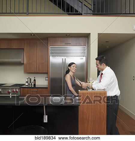 Picture - Asian couple in kitchen. Fotosearch