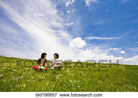 Stock Photo - Asian couple playing drums in meadow. Fotosearch