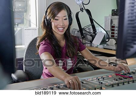 Stock Photo - Asian dj working at radio station. Fotosearch