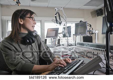 Stock Photograph - Asian dj working at radio station. Fotosearch