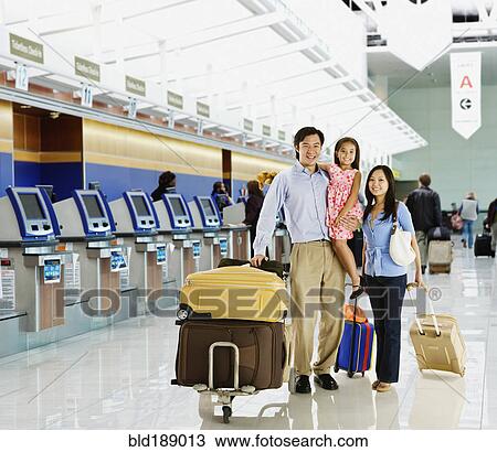 Stock Image - Asian family posing in airport. Fotosearch