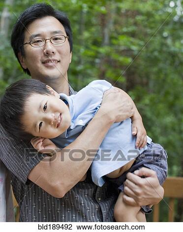 Asian father carrying son View Large Photo Image Stock Image - Asian father carrying son. Fotosearch