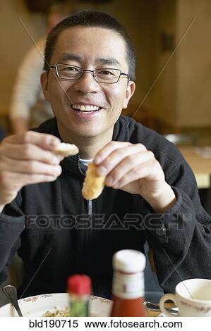 Asian man eating in restaurant View Large Photo Image Stock Photography - Asian man eating in restaurant. Fotosearch