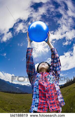 Asian man lifting ball in remote field View Large Photo Image Stock Photo - Asian man lifting ball in remote field. Fotosearch