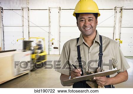 Stock Image - Asian man working in warehouse. Fotosearch