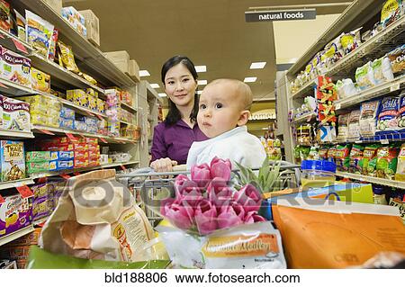 Stock Photograph - Asian mother shopping in grocery store with daughter. Fotosearch