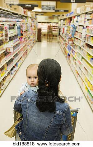 Stock Photo - Asian mother shopping with baby in grocery store. Fotosearch
