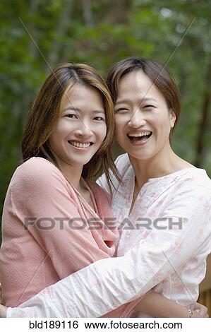 Asian sisters hugging View Large Photo Image Stock Photograph - Asian sisters hugging. Fotosearch
