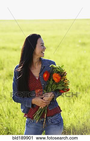 Asian woman holding bouquet of wildflowers View Large Photo Image Stock Image - Asian woman holding bouquet of wildflowers. Fotosearch