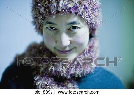 Stock Image - Asian woman in knitted hat and scarf. Fotosearch