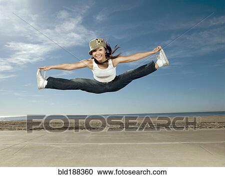 Stock Image - Asian woman jumping in air. Fotosearch