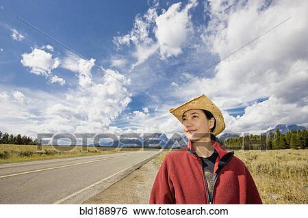 Stock Photograph - Asian woman on remote highway. Fotosearch