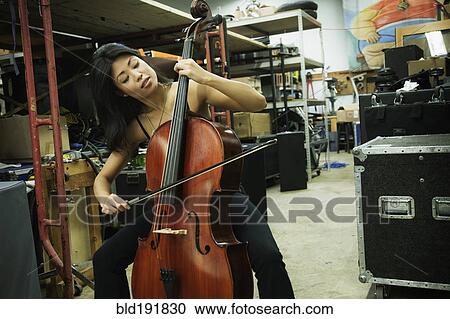 Asian woman playing cello in warehouse View Large Photo Image Stock Image - Asian woman playing cello in warehouse. Fotosearch