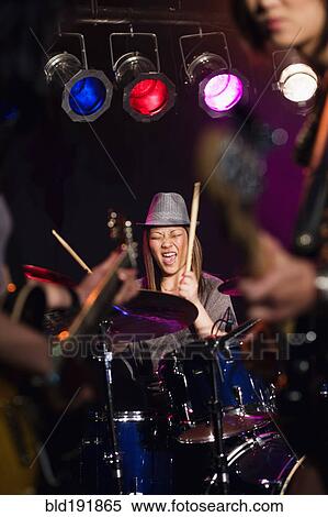 Stock Photography - Asian woman playing drums onstage. Fotosearch