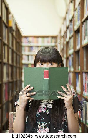 Asian woman reading book in library View Large Photo Image Stock Photography - Asian woman reading book in library. Fotosearch