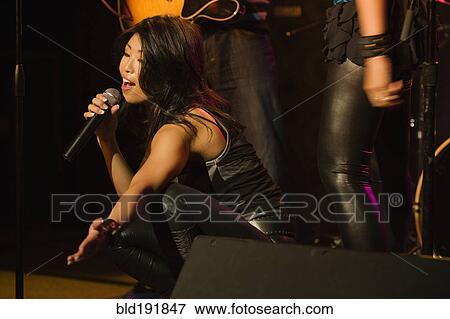 Stock Photo - Asian woman singing onstage. Fotosearch