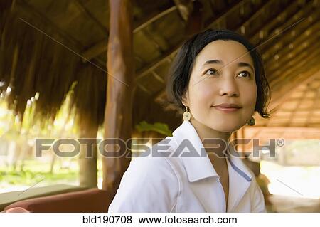 Stock Photo - Asian woman sitting in hut. Fotosearch
