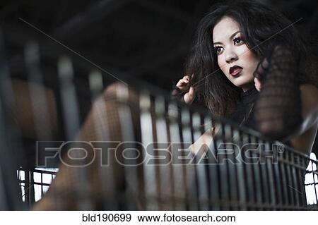 Stock Photo - Asian woman sitting in shopping cart. Fotosearch