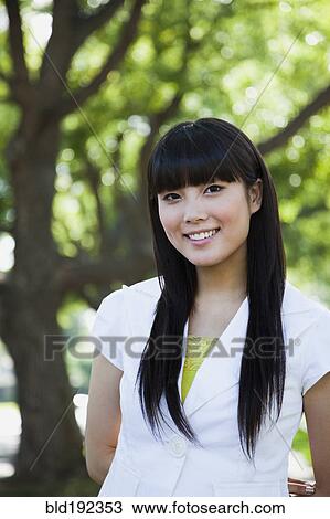 Asian woman smiling in park View Large Photo Image Stock Image - Asian woman smiling in park. Fotosearch