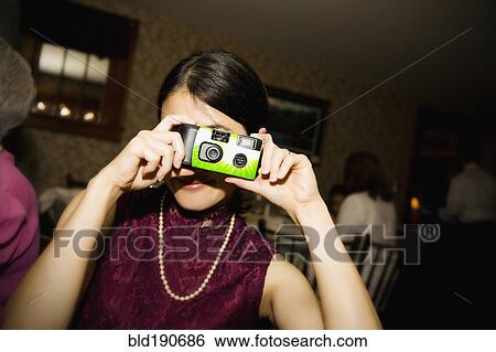 Stock Photograph - Asian woman taking photograph. Fotosearch