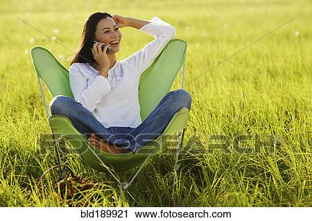 Asian woman using cell phone in meadow View Large Photo Image Stock Image - Asian woman using cell phone in meadow. Fotosearch