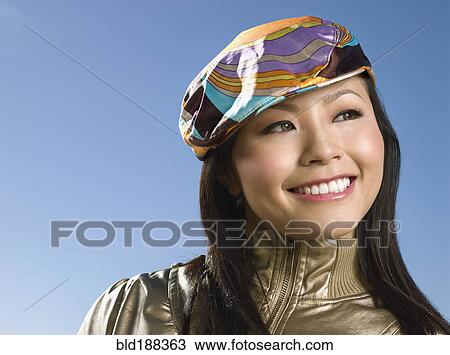 Stock Image - Asian woman wearing hat. Fotosearch