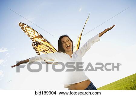 Picture - Asian woman with butterfly standing with arms outstretched. Fotosearch
