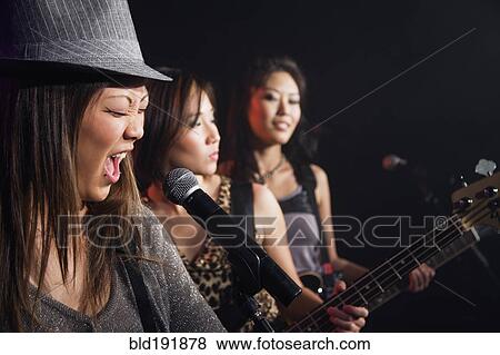 Asian women singing and playing guitar onstage View Large Photo Image Stock Photo - Asian women singing and playing guitar onstage. Fotosearch
