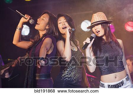 Stock Photo - Asian women singing onstage. Fotosearch