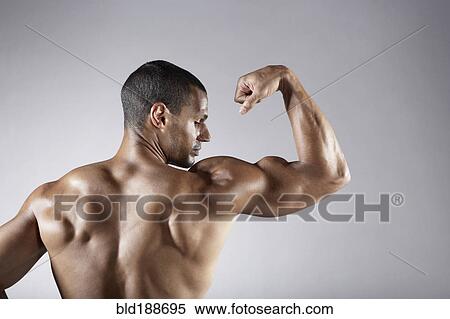 Bare chested mixed race man flexing biceps View Large Photo Image Stock Photography - Bare chested mixed race man flexing biceps. Fotosearch
